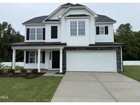 Charming two-story home featuring a two-car garage and a welcoming front porch at 83 W Emily Gardens Dr, Selma, NC 27576