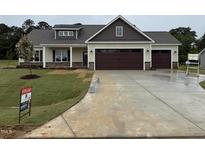 Inviting new construction home with a three-car garage and neatly sodded front lawn at 87 Tee Dr, Selma, NC 27576