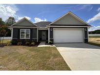 Charming single-story home with a two-car garage and landscaped front yard at 89 W Emily Gardens Dr, Selma, NC 27576