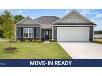 Charming single-story home boasts a well-manicured lawn and attached two-car garage at 89 W Emily Gardens Dr, Selma, NC 27576