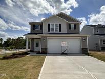 Charming two-story home featuring a two-car garage, neutral siding, and a well-manicured lawn and driveway at 9 W Emily Gardens Dr, Selma, NC 27576