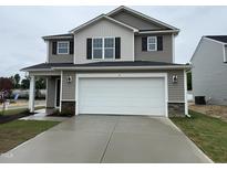 Two-story home with a two-car garage, neutral siding, and a well-maintained lawn on a cloudy day at 9 W Emily Gardens Dr, Selma, NC 27576