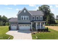 Beautiful gray two-story home featuring a two-car garage and a charming front porch at 102 E Star Foal Ln, Wendell, NC 27591