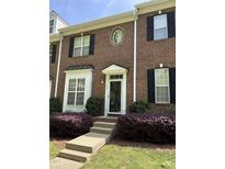 Charming brick townhouse with black shutters and manicured landscaping creates curb appeal at 108 W Savannah Ridge Rd, Holly Springs, NC 27540
