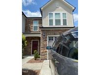 Inviting two-story home featuring stone accents, a driveway, and a well-maintained facade at 1129 Kudzu St, Durham, NC 27713