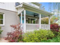 Inviting front porch with a porch swing, blue ceiling and white railings, perfect for relaxing outdoors at 200 Lincoln Ct, Raleigh, NC 27610
