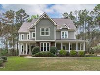 Charming two-story home featuring a stone base, welcoming porch and detailed gable roof at 2408 Merion Creek Dr, Apex, NC 27539