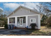 Charming bungalow-style home with gray siding, brick accents, and a screened-in front porch at 257 E Raleigh Blvd, Rocky Mount, NC 27801