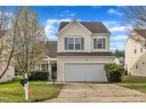 Charming two-story home boasts a manicured lawn and attached two-car garage at 2604 Smoky Topaz Ln, Raleigh, NC 27610