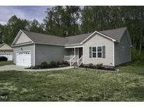 Charming one-story home featuring manicured lawn, attached garage, and traditional siding at 40 Patricia S Vann Ct, Dunn, NC 28334
