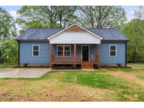 Charming blue home with a cozy front porch and well-maintained lawn at 508 N Charles St, Mebane, NC 27302