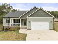 Charming home featuring a covered porch, two-car garage, and nicely landscaped front yard at 52 Sagebrook Ct, Zebulon, NC 27597