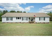 Charming ranch-style home with vinyl siding, black shutters, manicured lawn, and a welcoming front porch at 660 Our Way, Linden, NC 28356