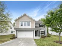 Charming two-story home features a two-car garage, well-maintained lawn, and inviting curb appeal on a sunny day at 7 Moonbeam Ct, Durham, NC 27712