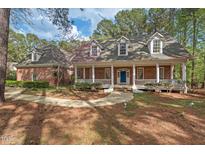 Charming brick home with a welcoming front porch and manicured landscaping at 7002 Old Trail Dr, Durham, NC 27712
