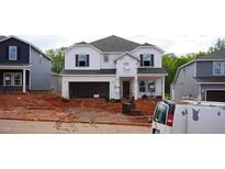 Two-story home showcasing an attached two-car garage awaiting finishing touches and landscaping at 709 Deschutes Dr, Garner, NC 27529