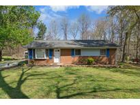 Charming brick home with well-maintained lawn and mature trees offering great curb appeal at 711 Melanie St, Durham, NC 27704