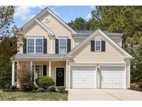 Charming two-story home with a well-manicured lawn and attached two-car garage at 103 Woolard Way, Apex, NC 27502