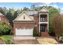 Charming two-story brick home with a two-car garage and landscaped front yard, evoking suburban elegance at 1104 Hobson Ct, Raleigh, NC 27607