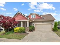 Charming single-Gathering home boasts a manicured lawn, colorful landscaping, and a two-car garage at 1108 Cadence Ln, Durham, NC 27703