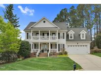 Inviting two-story traditional-style home boasting a charming double porch and well-manicured front lawn at 1113 Colonial Club Road Rd, Wake Forest, NC 27587