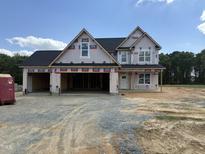 New construction showing the exterior elevation with a three car garage and architectural roof shingles at 112 Surles Landing Way, Benson, NC 27504