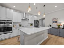 Bright kitchen features a spacious island, stainless steel appliances, and pendant lighting at 1726 Wimberly Rd, Apex, NC 27523