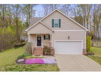 Charming home featuring a well-manicured lawn and an attached two-car garage and beautiful landscaping at 190 Alcock Ln, Youngsville, NC 27596