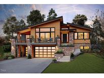 Striking home featuring a modern design, warm wood accents, stone details and a welcoming two-car garage at 2637 Buckeye Ct, Wake Forest, NC 27587