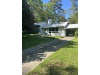 Charming single-story home features a green door, chimney, carport, and lovely landscaping at 3438 Leonard St, Raleigh, NC 27607