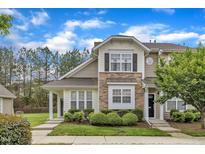 Charming townhome with stone accents, manicured landscaping, and inviting entrance under a blue sky at 345 Red Elm Dr, Durham, NC 27713