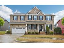 Beautiful two-story brick home with manicured lawn, attached garage, and inviting front porch at 4008 Sykes St, Cary, NC 27519