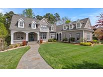 Beautiful gray home with a well-manicured lawn and stone walkway leading to the front entrance at 417 Westbury Dr, Chapel Hill, NC 27516