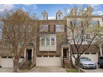 Beautiful brick townhome featuring an attached garage, a small portico, and tasteful landscaping at 452 Panorama Park Pl, Cary, NC 27519