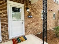 Inviting front entrance featuring a white door, brick facade, and stylish exterior lighting at 506 N Greensboro St # Apt 33, Carrboro, NC 27510