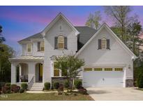 Charming two-story home features a white brick exterior, two-car garage, and beautifully landscaped front yard at 5180 Glen Creek Trl, Garner, NC 27529
