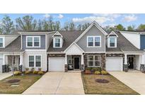 Charming townhome featuring a stone facade, gray shingle accents, and well-maintained landscaping at 53 Whitley Ridge Dr, Clayton, NC 27527