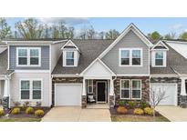 Charming two-story townhome with a stone and siding exterior, complemented by a well-manicured lawn at 53 Whitley Ridge Dr, Clayton, NC 27527