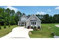 Beautiful two-story home featuring gray siding, black roof, and manicured front lawn at 6521 Camellia Creek Dr, Raleigh, NC 27603