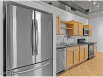 Modern kitchen features stainless steel appliances and light wood cabinets with an industrial design at 700 Market St # 214, Chapel Hill, NC 27516