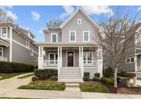 Charming two-story home featuring a covered front porch with white columns and manicured landscaping at 711 Virginia Ave, Raleigh, NC 27604