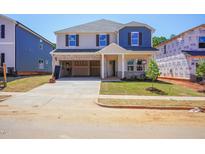 Charming two-story home featuring a brick-accented garage, a manicured lawn, and a welcoming front entrance at 721 Deschutes Dr, Garner, NC 27529