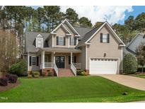 Charming two-story home with a well-manicured lawn, inviting front porch, and an attached two-car garage at 7252 Bedford Ridge Dr, Apex, NC 27539
