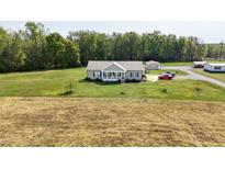 Charming single-story home with a welcoming front porch and a spacious green lawn surrounded by trees at 8079 Stone Heritage Rd, Middlesex, NC 27557