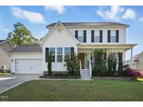 Charming two-story home with white siding, black shutters, and a well-manicured front lawn at 1039 S Philwood Ct, Fuquay Varina, NC 27526