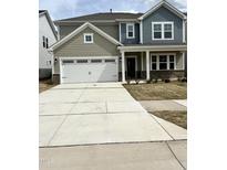Two-story home featuring a spacious garage, manicured lawn, and a blend of siding and brick accents at 1140 Sun Springs Rd, Wake Forest, NC 27587