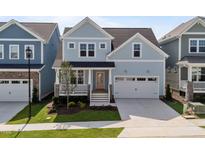 Charming two-story home with light blue siding, a welcoming front porch, and a two-car garage at 1237 Porters Call Dr, Wendell, NC 27591