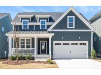 Charming two-story home with a well-manicured lawn and inviting front porch and a two car garage at 1237 Porters Call Dr, Wendell, NC 27591