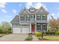 Charming two-story home boasts a red door, three-car garage, and professionally landscaped front yard at 200 Windy Knoll Cir, Chapel Hill, NC 27516
