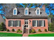 Charming brick home featuring a cedar shake roof and dormer windows, offering classic curb appeal at 228 Old Colony Way, Rocky Mount, NC 27804